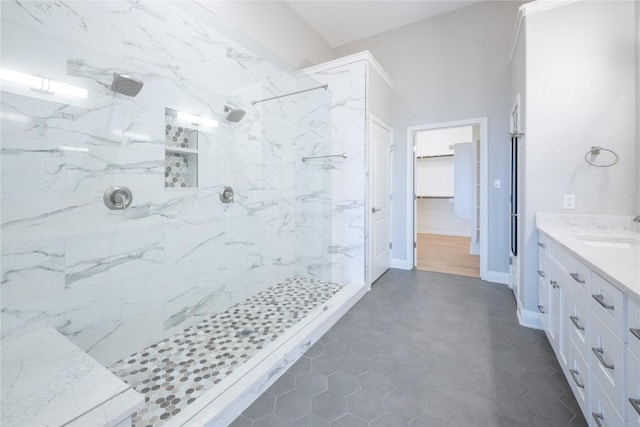 bathroom featuring a tile shower and vanity