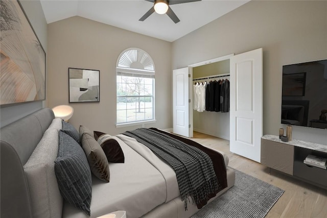 bedroom featuring light wood-type flooring, a closet, ceiling fan, and lofted ceiling