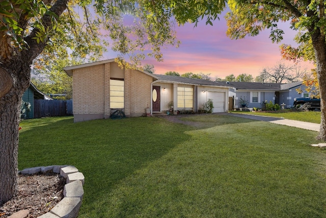 ranch-style home with a garage and a lawn