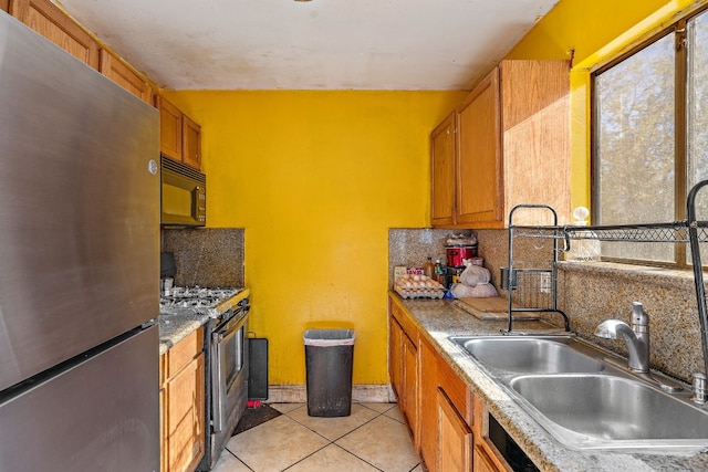 kitchen with backsplash, sink, light tile patterned floors, and appliances with stainless steel finishes