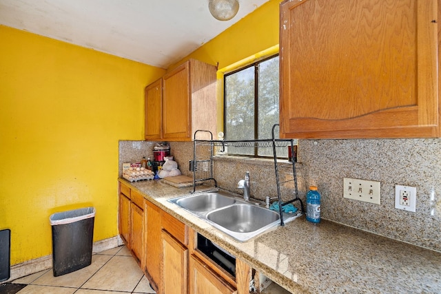 kitchen with decorative backsplash, sink, and light tile patterned floors