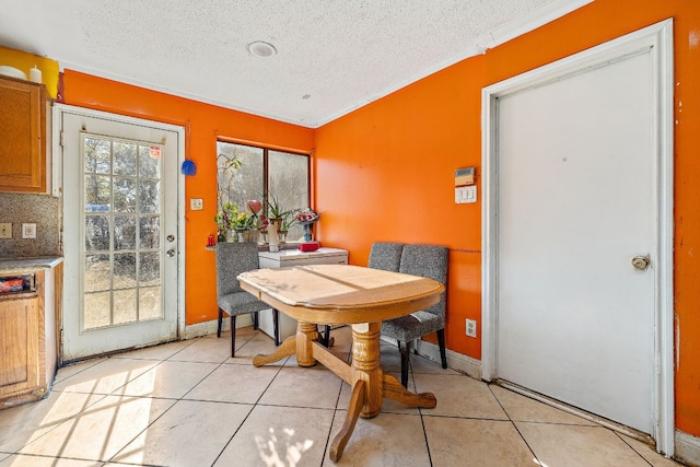 tiled dining room featuring crown molding and a textured ceiling