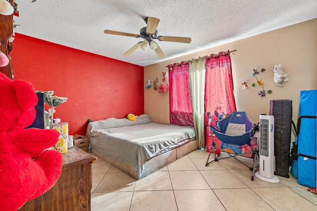 tiled bedroom with ceiling fan and a textured ceiling