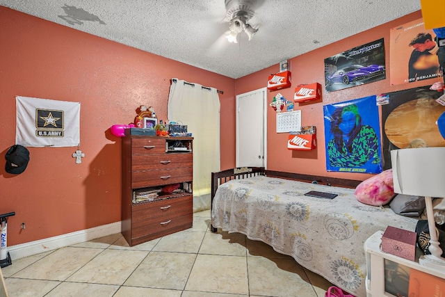 tiled bedroom featuring ceiling fan and a textured ceiling