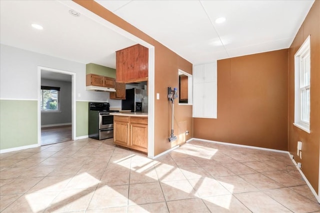 kitchen with light tile patterned floors and stainless steel appliances