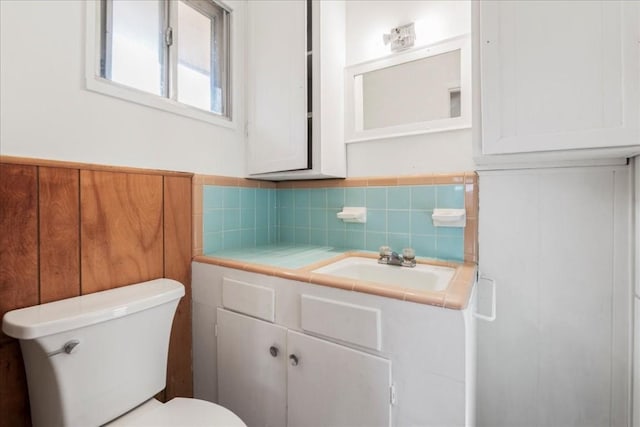 bathroom featuring decorative backsplash, vanity, and toilet