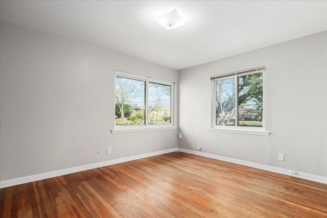 spare room featuring light hardwood / wood-style flooring and a healthy amount of sunlight