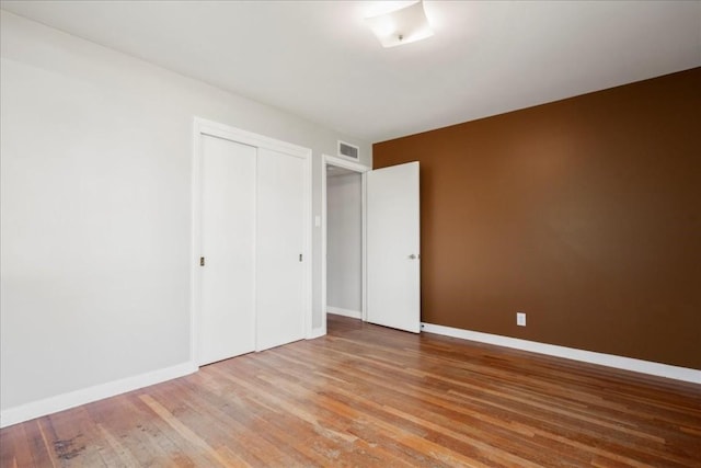 unfurnished bedroom with hardwood / wood-style floors and a closet