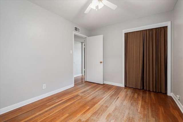 unfurnished bedroom featuring a closet, light hardwood / wood-style floors, and ceiling fan