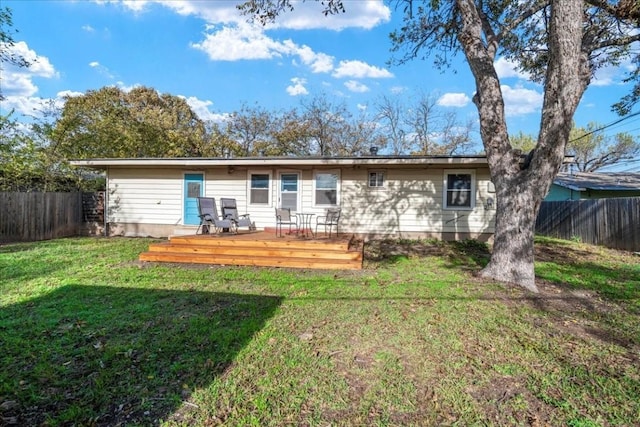 rear view of property with a yard and a wooden deck