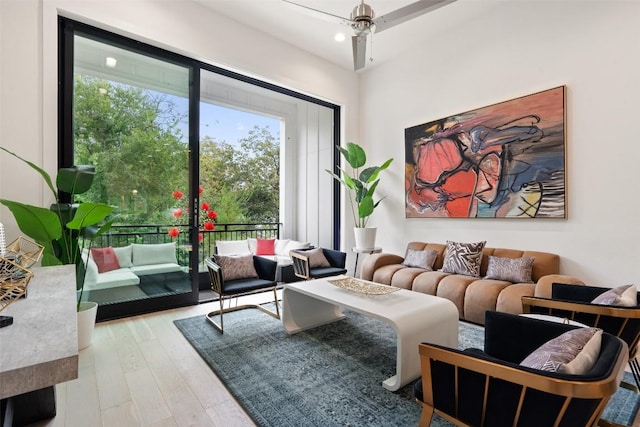 living room featuring ceiling fan and light hardwood / wood-style flooring