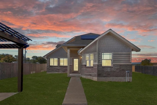 craftsman inspired home featuring solar panels and a lawn