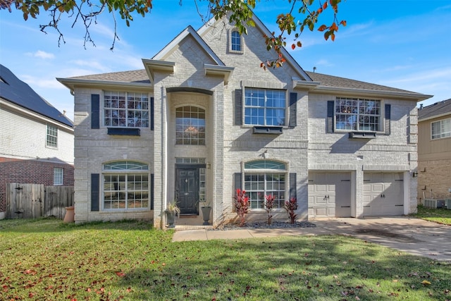 view of front of property featuring central AC unit, a garage, and a front lawn