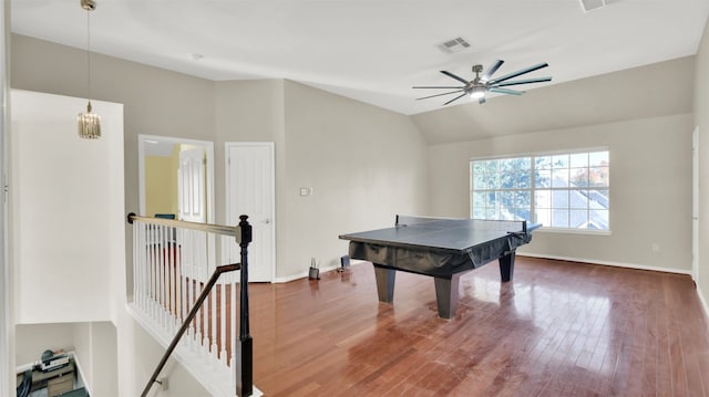 game room with ceiling fan with notable chandelier, lofted ceiling, and dark wood-type flooring