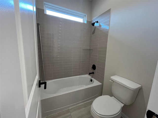 bathroom featuring toilet and tiled shower / bath