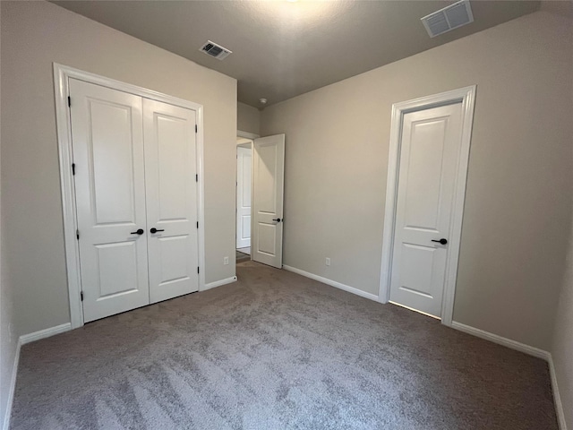 unfurnished bedroom featuring light colored carpet and a closet