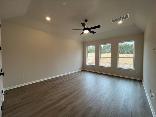 empty room featuring dark wood-type flooring, vaulted ceiling, and ceiling fan