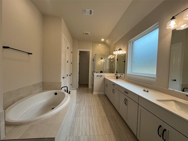 bathroom featuring vanity, vaulted ceiling, and separate shower and tub