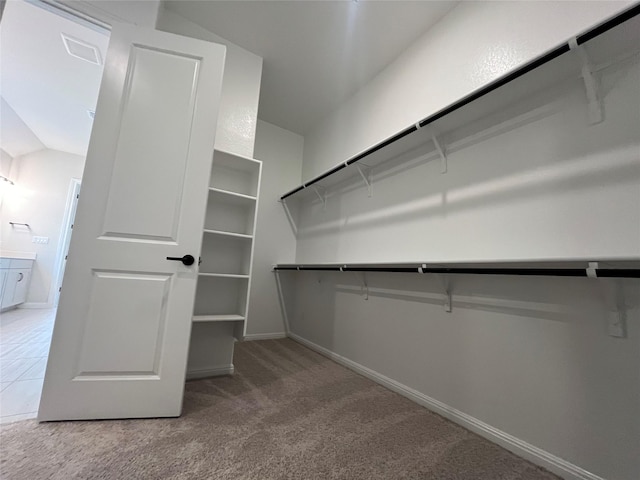 spacious closet with lofted ceiling and carpet floors