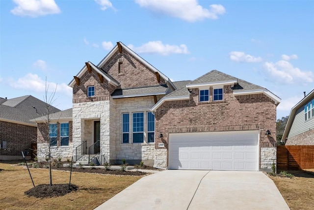 view of front of house featuring stone siding, brick siding, driveway, and fence