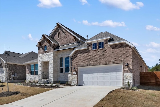 view of front of home with brick siding, roof with shingles, fence, stone siding, and driveway