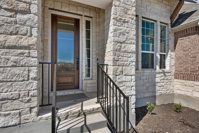 property entrance featuring stone siding and brick siding