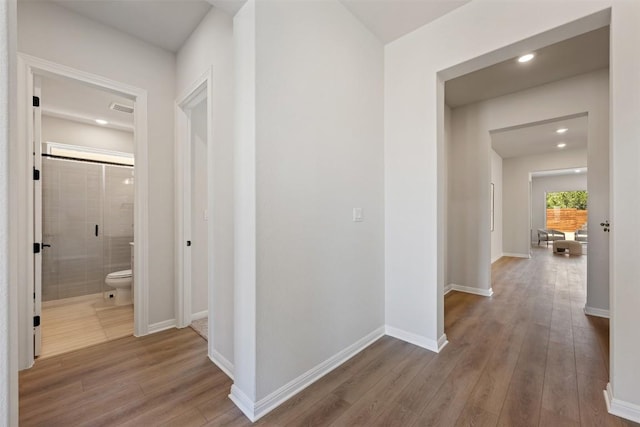 corridor featuring recessed lighting, wood finished floors, visible vents, and baseboards