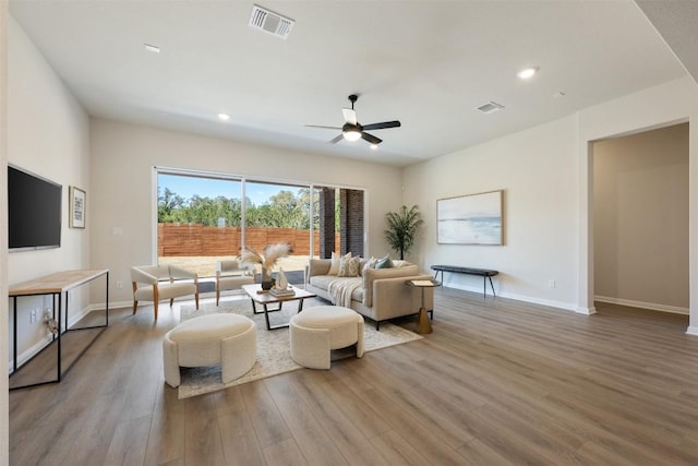 living area featuring baseboards, visible vents, wood finished floors, and recessed lighting