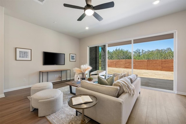 living area with a healthy amount of sunlight, baseboards, and wood finished floors