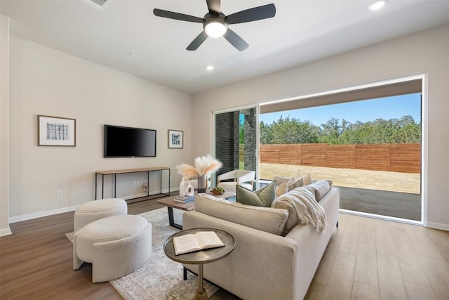 living area featuring recessed lighting, baseboards, and wood finished floors