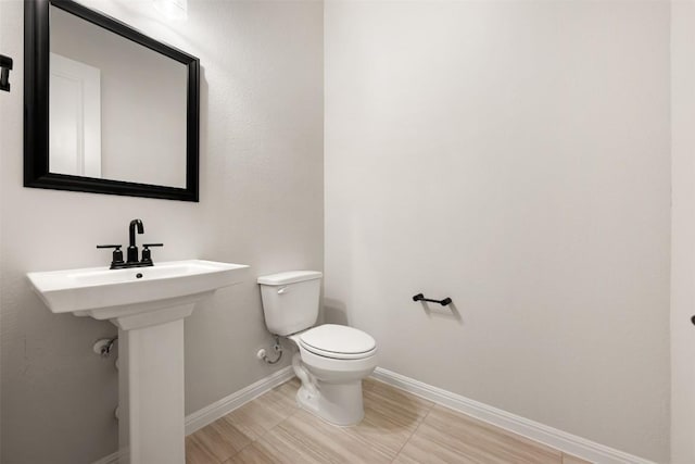 bathroom featuring toilet and baseboards