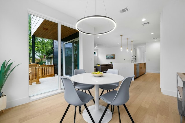 dining space with light wood-type flooring and sink