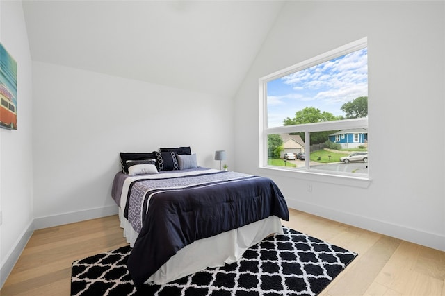 bedroom featuring wood-type flooring and vaulted ceiling