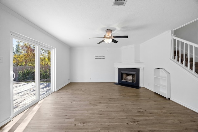 unfurnished living room featuring a textured ceiling, ceiling fan, dark hardwood / wood-style flooring, and a fireplace