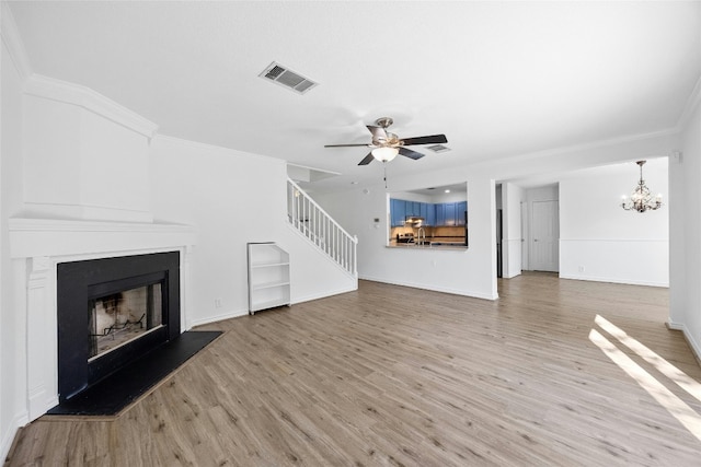 unfurnished living room featuring ceiling fan with notable chandelier, light hardwood / wood-style floors, and ornamental molding