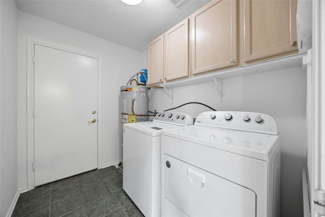 laundry room with cabinets, a textured ceiling, separate washer and dryer, and dark tile patterned flooring