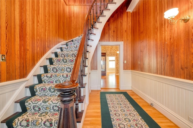 stairway with hardwood / wood-style flooring and wooden walls