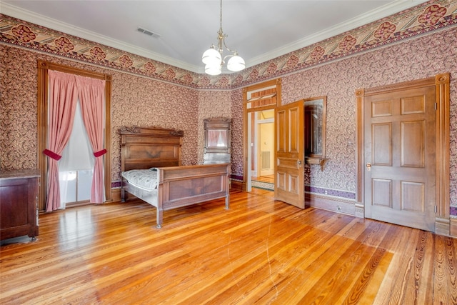 unfurnished bedroom featuring a chandelier, light hardwood / wood-style floors, and ornamental molding