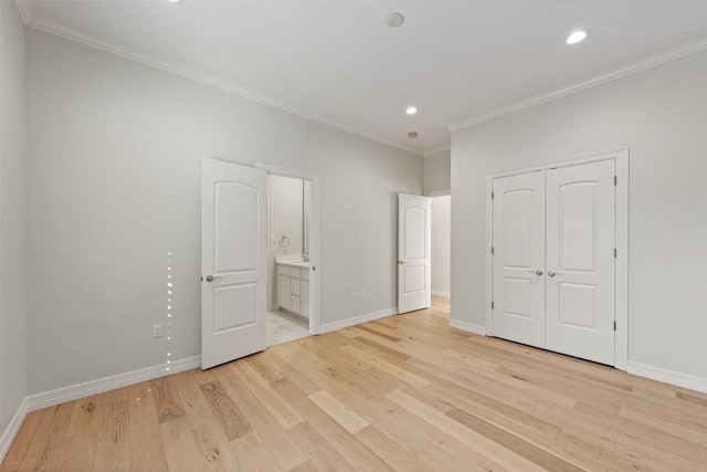 unfurnished bedroom with light wood-type flooring, ornamental molding, and a closet