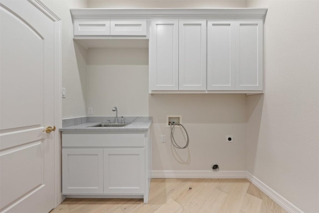 laundry room featuring electric dryer hookup, cabinets, sink, hookup for a washing machine, and light hardwood / wood-style flooring