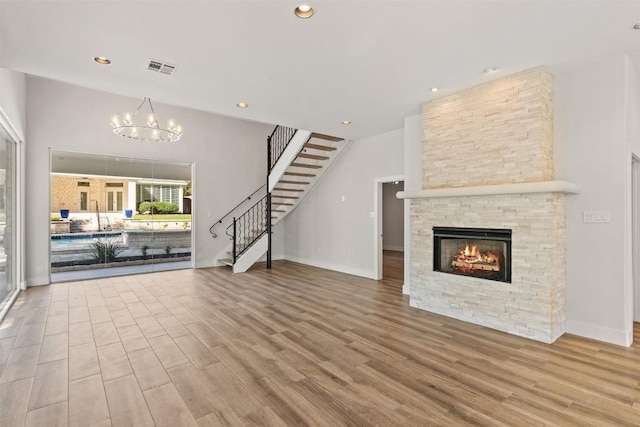 unfurnished living room with a fireplace, hardwood / wood-style floors, and a notable chandelier