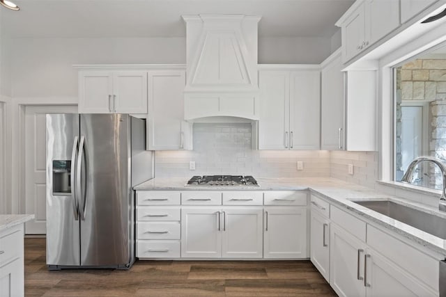 kitchen with sink, appliances with stainless steel finishes, dark hardwood / wood-style flooring, light stone counters, and white cabinetry