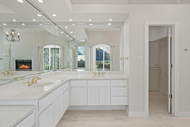 bathroom with crown molding, vanity, and a notable chandelier