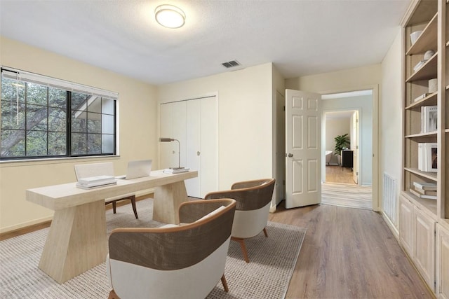 office space featuring a textured ceiling and light hardwood / wood-style floors