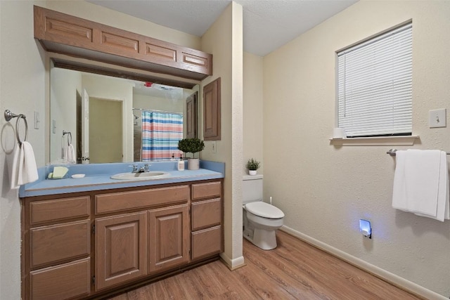 bathroom featuring hardwood / wood-style floors, vanity, curtained shower, and toilet