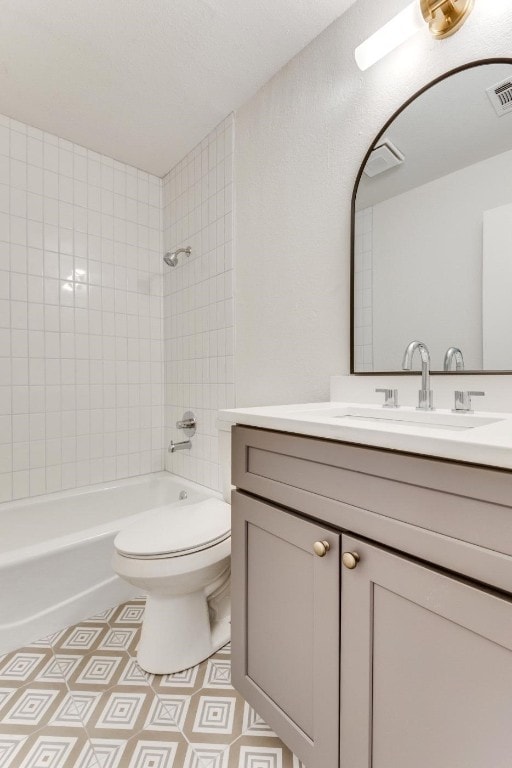 full bathroom featuring toilet, tiled shower / bath combo, and vanity