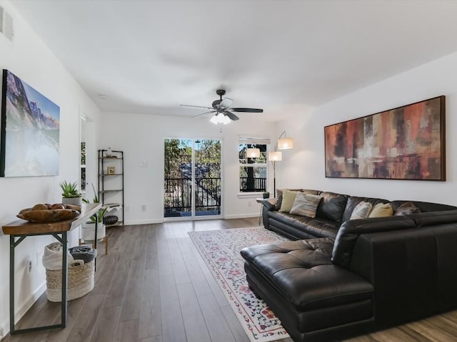 living room with visible vents, baseboards, wood finished floors, and a ceiling fan