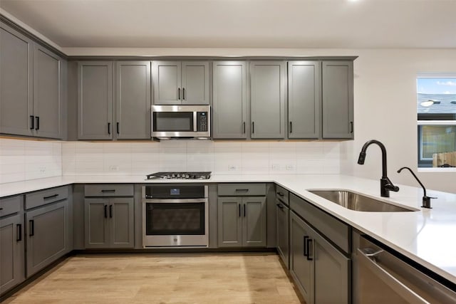 727 Palo Brea Loop, Hutto, TX 78634 - kitchen with stainless steel appliances, a sink, gray cabinets, and decorative backsplash