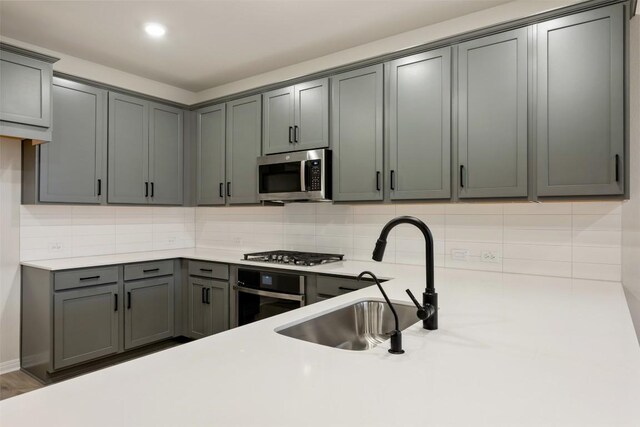 727 Palo Brea Loop, Hutto, TX 78634 - kitchen with stainless steel appliances, a sink, light countertops, and tasteful backsplash
