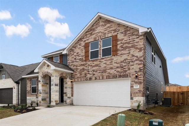 727 Palo Brea Loop, Hutto, TX 78634 - view of front of property with an attached garage, cooling unit, driveway, and stone siding